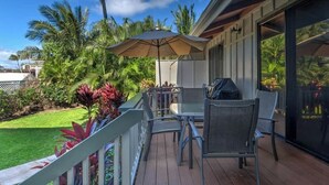 An outdoor patio with a table and chairs, a grill, and a large umbrella. - Royal Palm: AC, Private Lanai, Walk to Poipu Beach (Koloa)