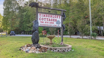 Señal para Timberloft Cottages con un número de contacto y sitio web.