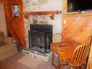 Cozy room with a fireplace, television, and comfortable seating area.