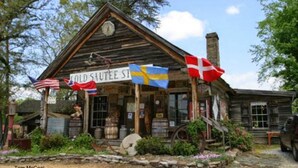 Un edificio rústico con un letrero que dice "COLD SAUTEE ST." Se exhiben banderas de Suecia y Dinamarca en el exterior.