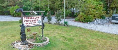 A sign for Timberloft Cottages with a contact number and website.