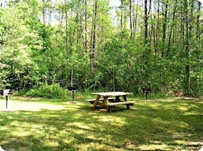 Enjoy a peaceful retreat in a serene natural setting, surrounded by lush greenery and tall trees.
