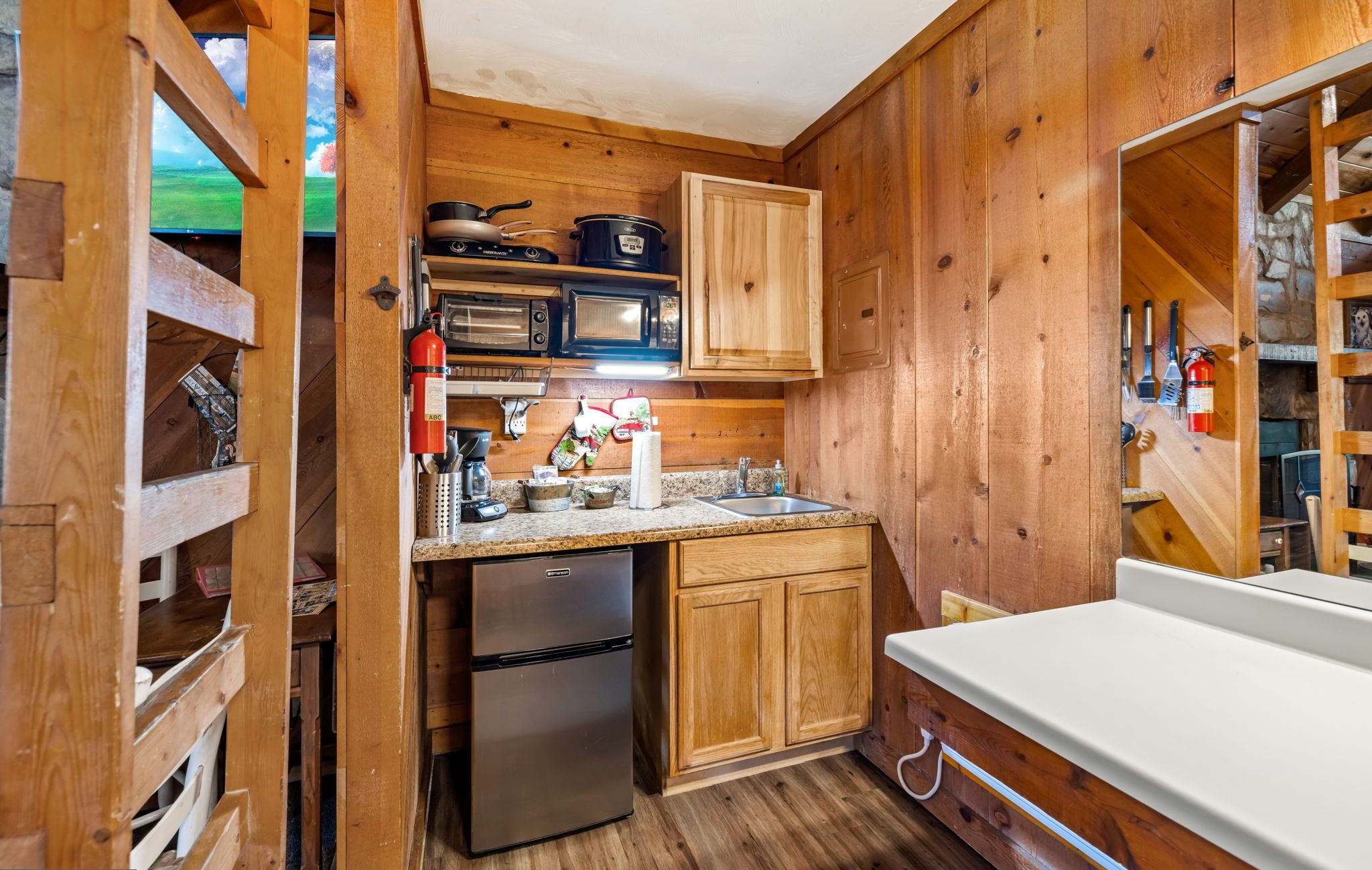 Una cocina compacta con armarios de madera, un refrigerador, un microondas y una estufa.