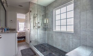 A modern bathroom with a glass-enclosed shower, a large window, and a vanity with a mirror and sink. - Close to Downtown, Midtown, GT, GWCC and Mercedes-Benz Stadium (Atlanta)