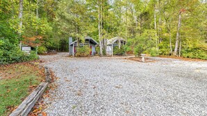 A gravel driveway leading to a cabin area surrounded by trees.