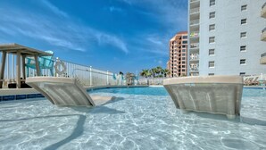 A clear swimming pool with lounge chairs and a high-rise building in the background. - Beautiful 3 Br 3B Gulf Front With Free Wifi Tennis, Pickle Ball, 2 Pools (Orange Beach)