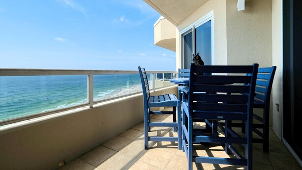 A balcony with a view of the ocean, a table, and blue chairs. - Beautiful 3 Br 3B Gulf Front With Free Wifi Tennis, Pickle Ball, 2 Pools (Orange Beach)