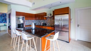 Una cocina moderna con una isla central, electrodomésticos de acero inoxidable y un salpicadero colorido.
