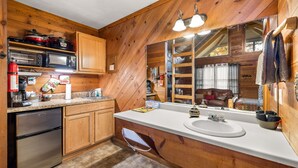 A kitchen with wooden cabinets, a microwave, a stove, and a sink.