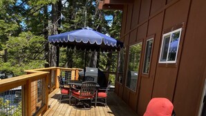 A deck with red lounge chairs, a table, and an umbrella. - Snow! March /April availability! Driveway snow plow included! Dog ok! Fast WiFi! (Homewood)