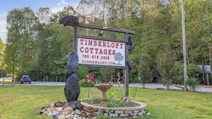 A sign for Timberloft Cottages with a phone number and website.