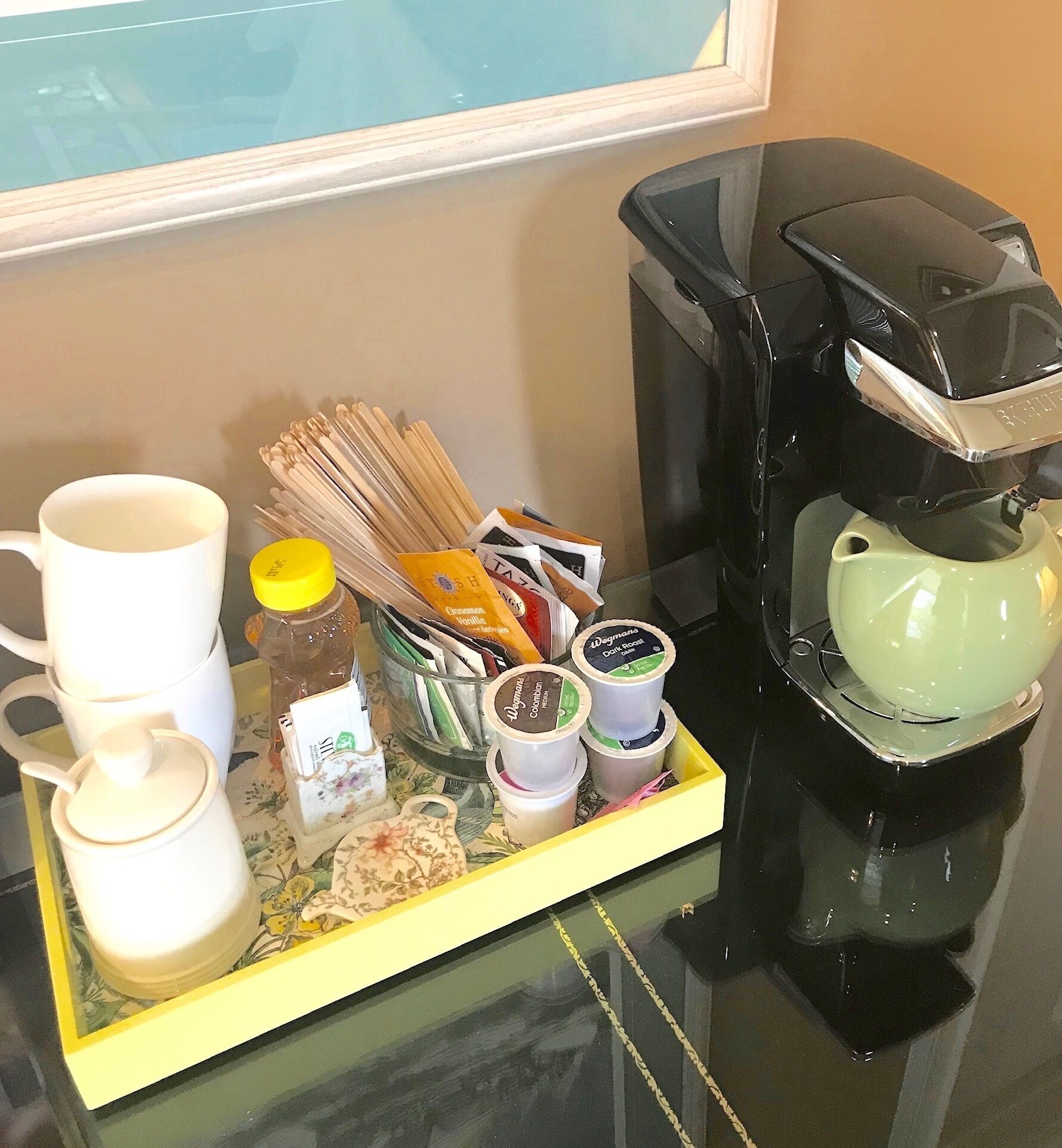 Un plateau contenant une cafetière, des tasses, du sucre et divers condiments, posé sur une table.