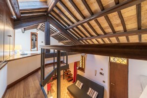 A multi-level interior with a wooden staircase, a sofa, and a door.