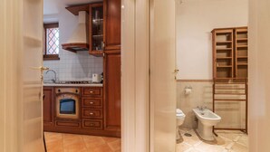 A kitchen with wooden cabinets, a built-in oven, and a window. - Amazing studio in Campo de' Fiori - Air Conditioning - Free Wi-Fi (Rome)