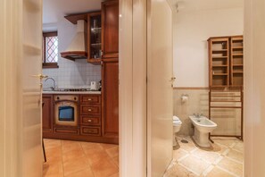 A kitchen with wooden cabinets, a built-in oven, and a window.