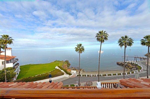 Enjoy ocean views from the comfort of our beachfront deck, surrounded by palm trees and a well-manicured lawn.