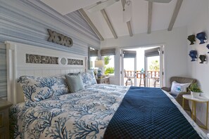 Relax in this serene bedroom with a large bed, wooden headboard, and cozy reading nook.