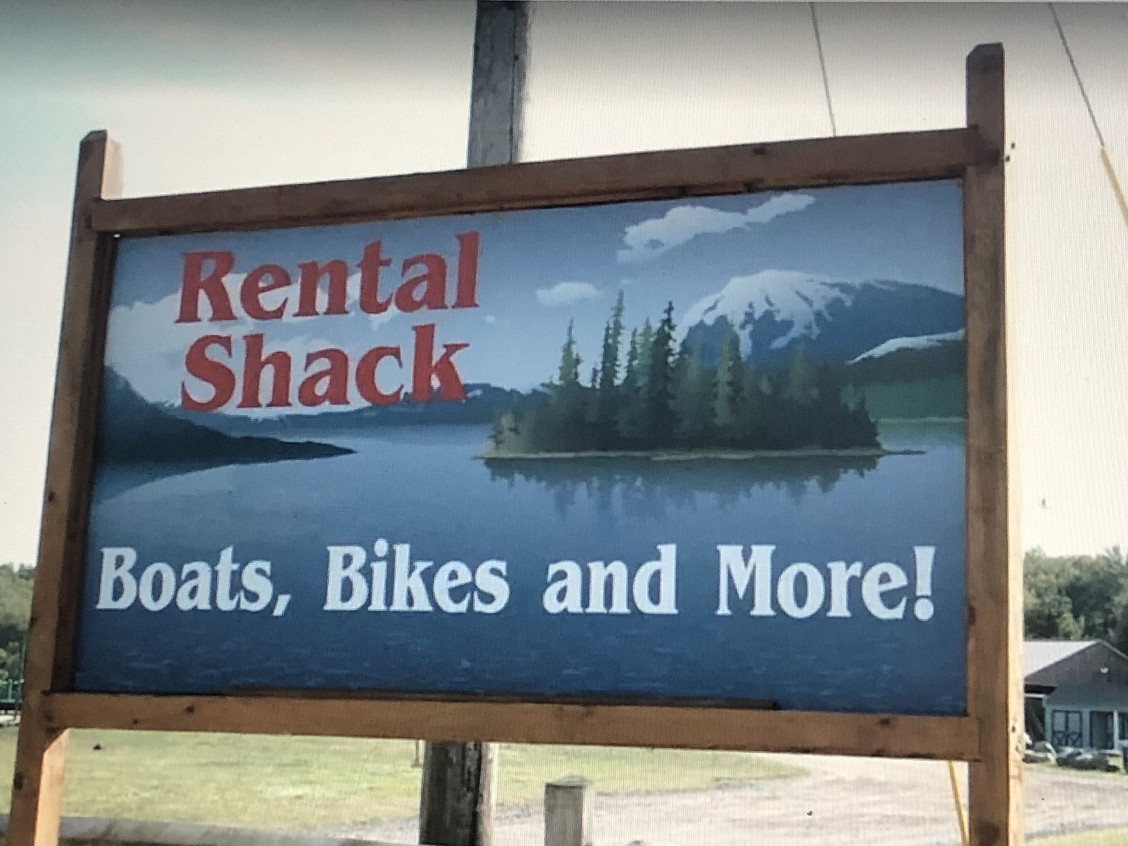 A sign for a rental shack offering boats, bikes, and more.