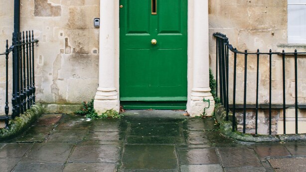 A green door with the number 25, set in a stone building with a white trim and a small window above the door. - Garden maisonette in Bath city centre (Bath)