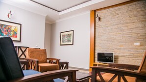 Una habitación con pared de ladrillo, un televisor y cuadros en la pared.