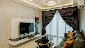 A modern living room with a flat-screen TV, a sofa, and a coffee table. - Residences at Daya by SR Home (Johor Bahru)