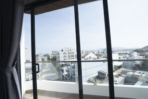 Varanda com vista para a cidade, janelas amplas e uma cortina.