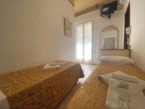A hotel room with two beds, a TV mounted on the wall, a mirror, and a window with curtains. - Hotel Nanni Garni (Rimini)