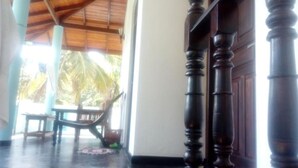 Uma escada de madeira com acabamento escuro, que leva a um quarto com parede branca e uma janela.