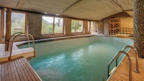 An indoor swimming pool with wooden walls and large windows. - Pahalgam hotel (Anantnag)