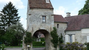 A stone building with a central archway, a small window, and a chimney.