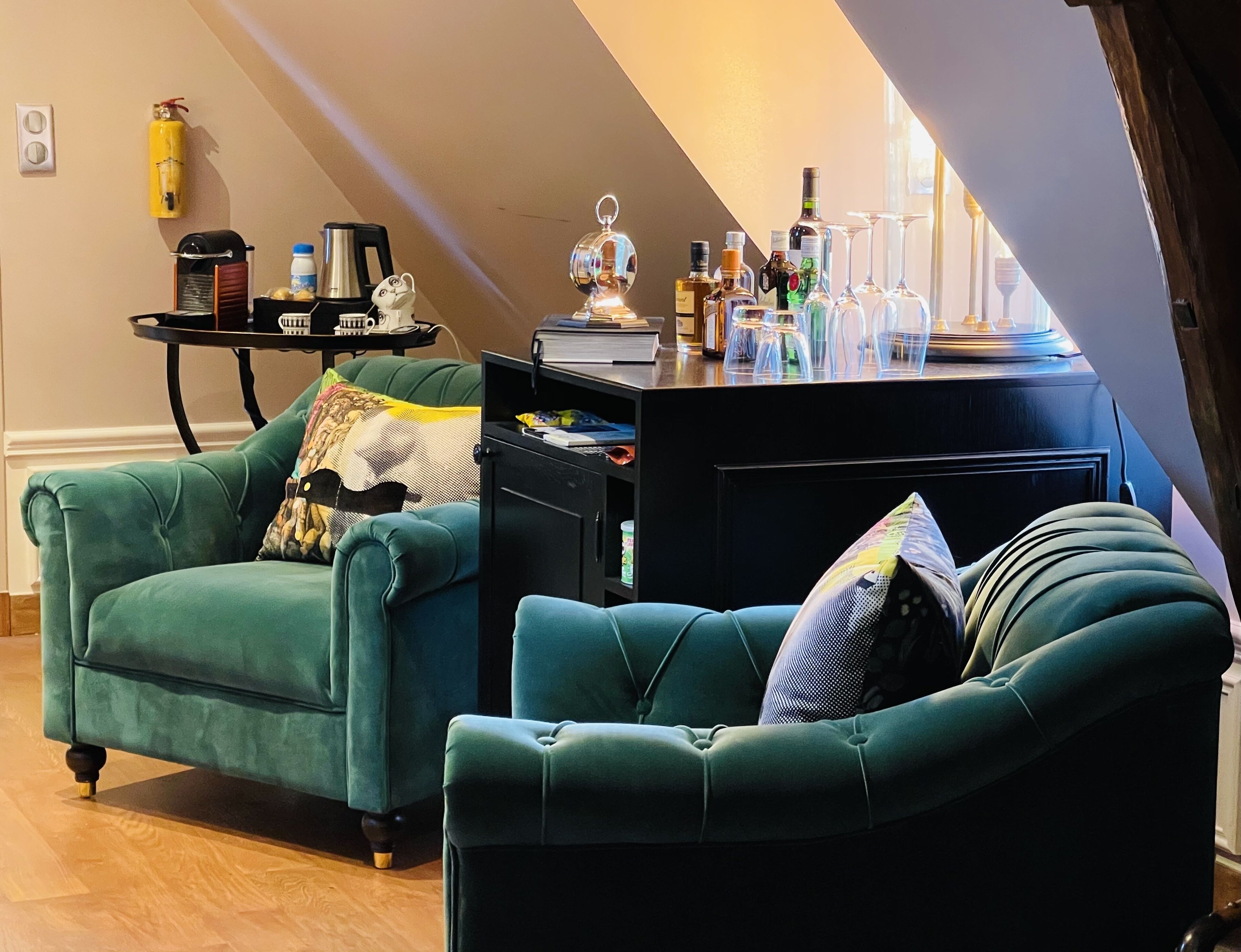 Una sala de estar acogedora con sillones color turquesa, un mueble multimedia negro y una mesa de centro.