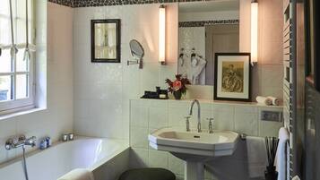 A bathroom with a bathtub, a sink, a mirror, and a vanity.