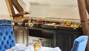 Un buffet con diversas opciones de comida y una zona de comedor con una mesa lista para dos.
