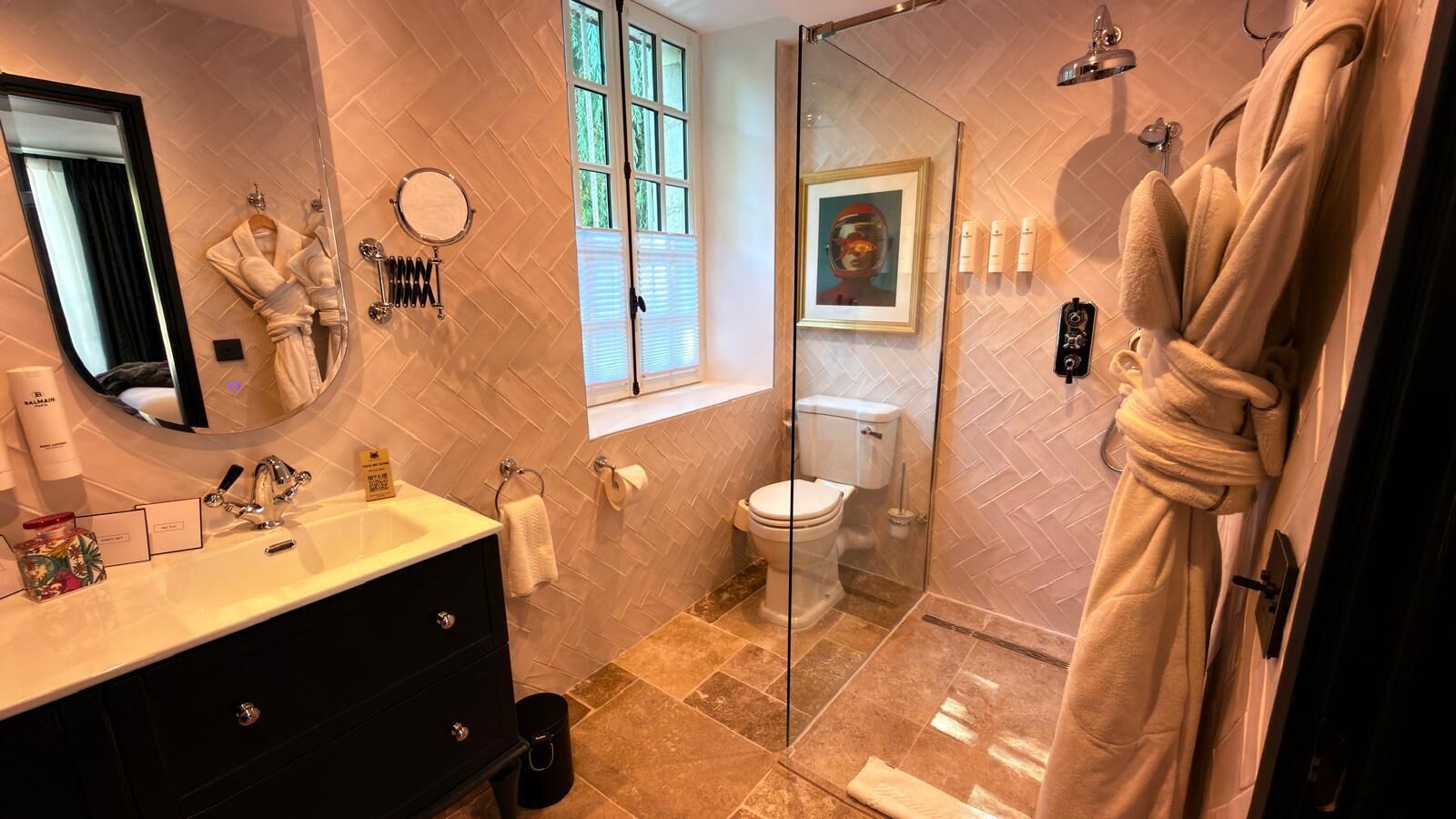 Une salle de bain avec une douche à parois de verre, des toilettes et un meuble-lavabo avec un miroir et un évier.