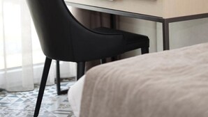 A hotel room with a bed, a desk with a chair, and a window with curtains. - Vila Europa (Struga)