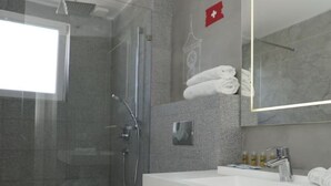 A modern bathroom with a glass-enclosed shower, a white sink, and a large mirror. - Vila Europa (Struga)