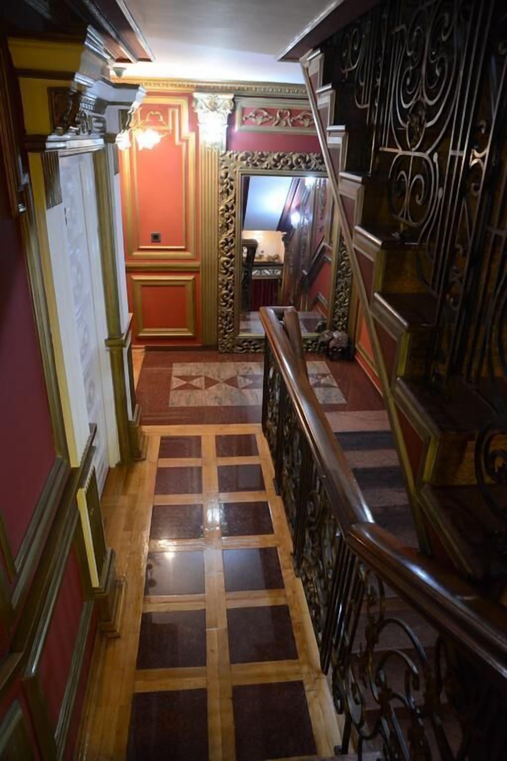 A staircase with ornate metal railings and a patterned floor.