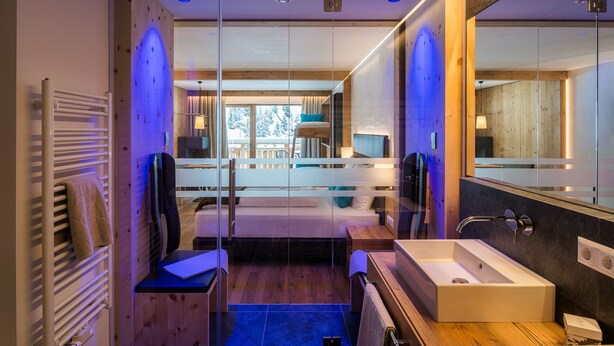 A modern bathroom with a large mirror, a wooden vanity, and a bathtub.