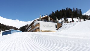 A snow-covered mountain with a building labeled "JOCHELIUS" and a ski lift in the foreground.
