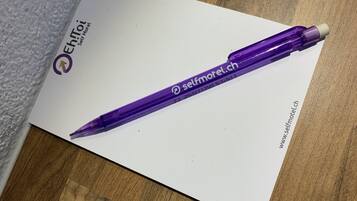 Un stylo violet avec le texte « selfmotel.ch » sur un fond blanc.