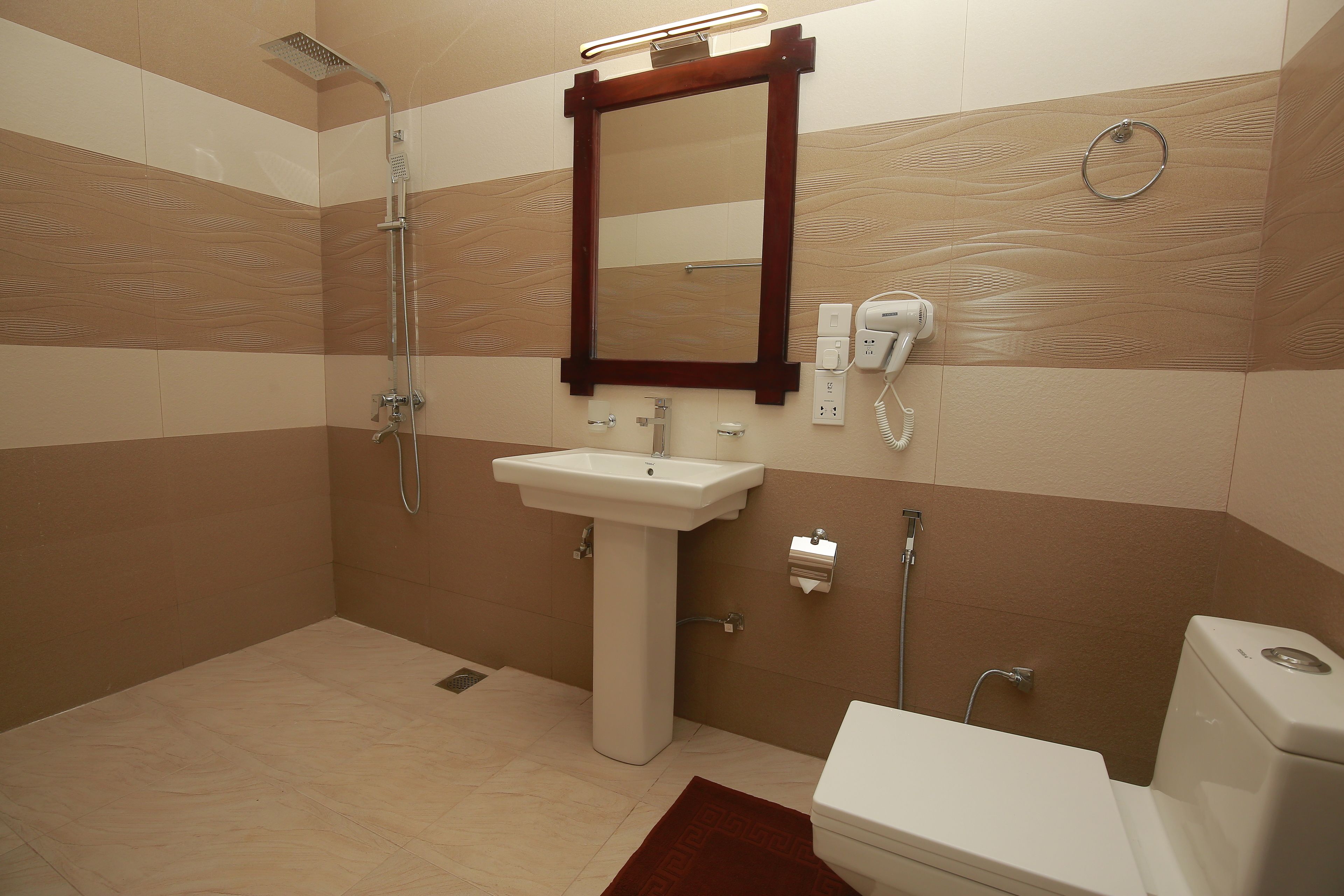 Une salle de bain équipée d’une douche, d’un lavabo, de toilettes et d’un miroir.