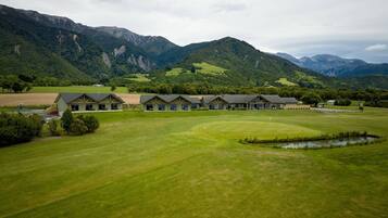 Un campo de golf con un club de campo y varias habitaciones de huéspedes.