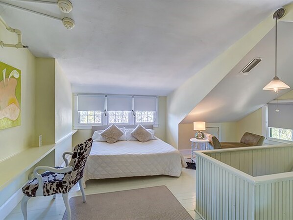 Une chambre à coucher avec un lit, une chaise, un bureau et une fenêtre.