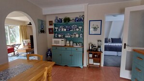 A cozy kitchen with a dining table, teal cabinets, and a variety of kitchenware. - The house for all seasons, occasions and ages. Perfect for families! (Greytown)