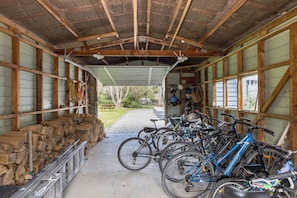 A covered storage area with bicycles, a stack of firewood, and a view of the outdoors. - The house for all seasons, occasions and ages. Perfect for families! (Greytown)
