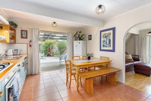 A kitchen with a dining area, a refrigerator, and a view to the outside. - The house for all seasons, occasions and ages. Perfect for families! (Greytown)