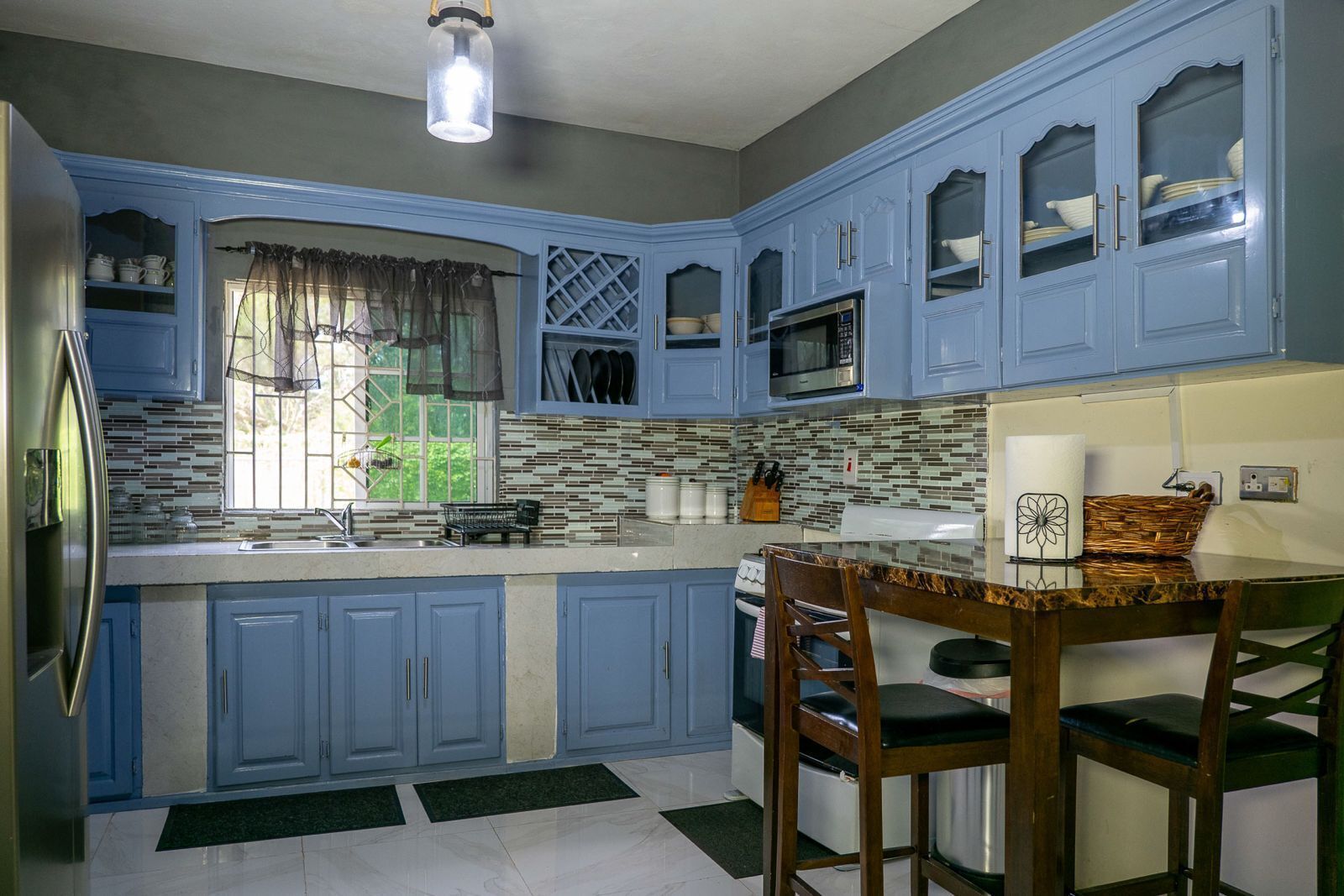 A kitchen with blue cabinets, a microwave, and a stove.