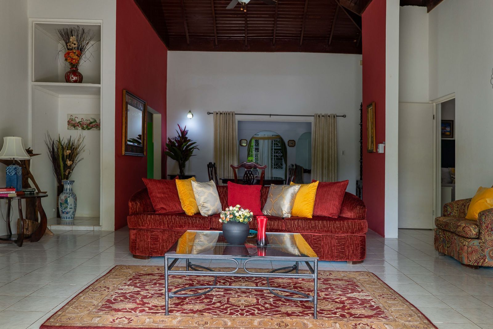 A living room with a red sofa, a coffee table, and a patterned rug.