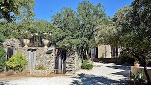 A stone building with a gravel driveway, surrounded by trees and greenery. - House / Villa - Gordes (Gordes)