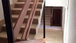 Un escalier avec des marches en bois et une rampe noire.
